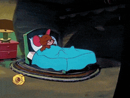 a cartoon jerry is sleeping in a bed with a blue blanket