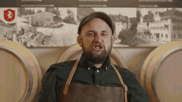 a man making a funny face in front of barrels