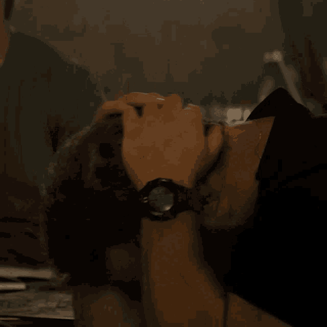 a man with a watch on his wrist has his hand on his face