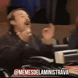 a man is sitting at a desk with his hands in the air and a caption that says " @memesdelaministrava "