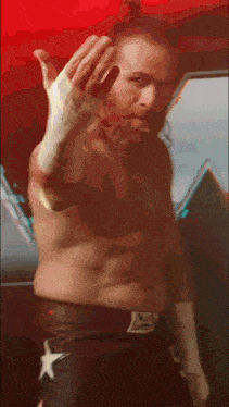 a shirtless man with a beard is making a peace sign