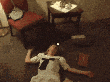 a woman in a white dress is laying on the floor near a box that says first aid