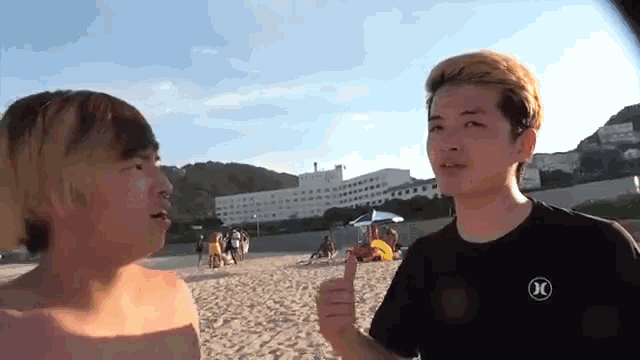 a man wearing a hurley shirt talks to another man