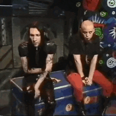 two men are sitting next to each other in front of a microphone .