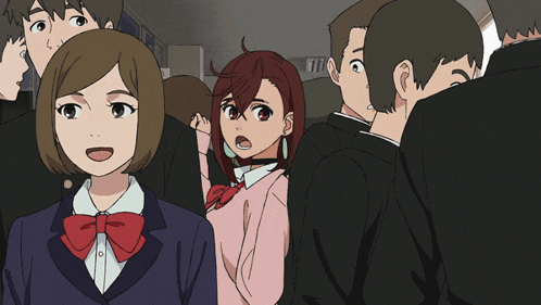 a group of people are standing in a room and one of them is wearing a pink shirt with a red bow