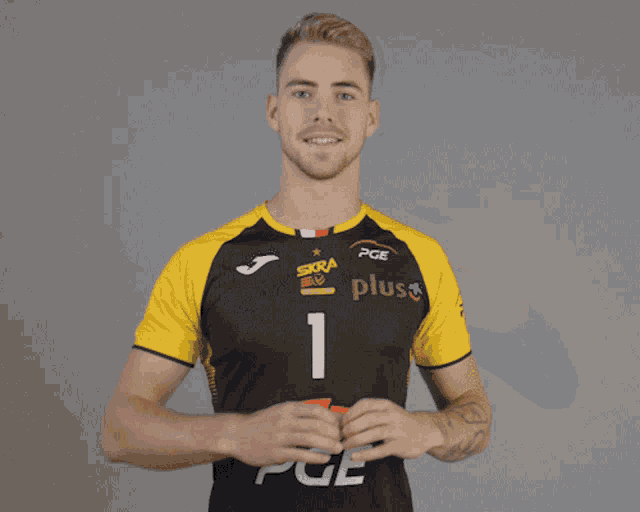 a man wearing a black and yellow shirt that says pge