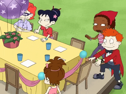 a group of cartoon characters are sitting around a table with balloons