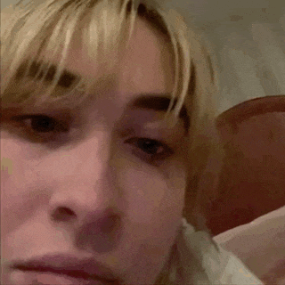 a close up of a woman 's face with blonde hair and a serious look on her face .