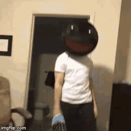 a person wearing a mask with a red mouth is standing in front of a door in a room .