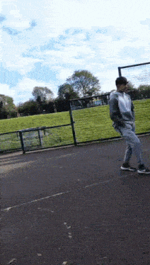 a man is standing on a basketball court in a park