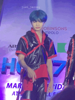 a boy with blue hair is standing in front of a sign that says robinsons antipolo