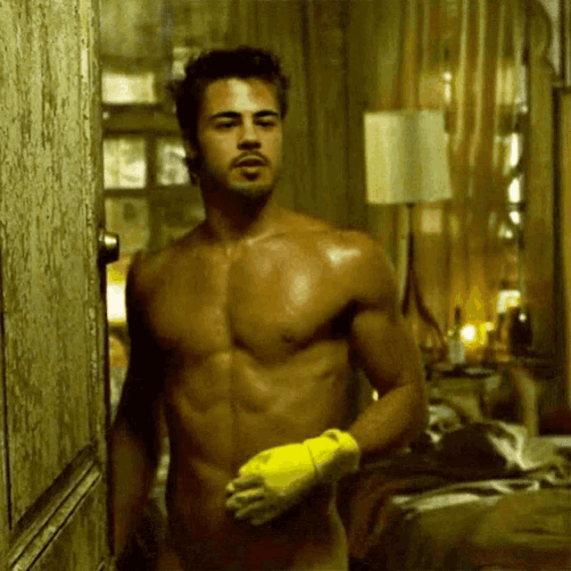 a shirtless man with a yellow glove on his hand