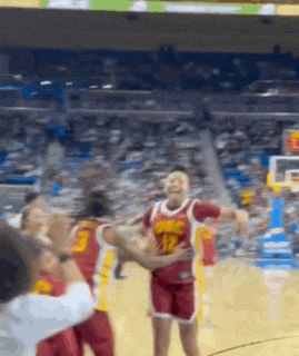 a group of basketball players are standing on a court .