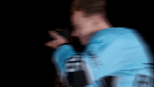 a blurry picture of a man wearing a blue jacket with the word ' abercrombie ' on it