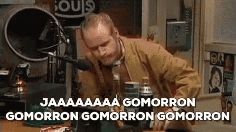 a man is sitting at a table in front of a microphone and saying gomorron gomorron gomorron gomorron .