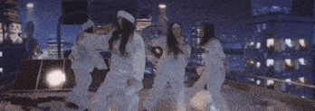 a group of women are dancing on a rooftop in front of a city skyline