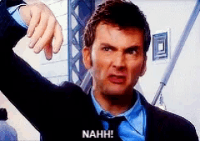 a man in a suit and tie is pointing his finger at the camera and says nahh