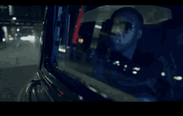 a man is sitting in a car looking out the window