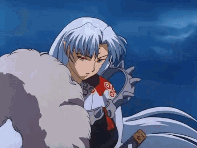 a man with long white hair is holding a sword in his hand .