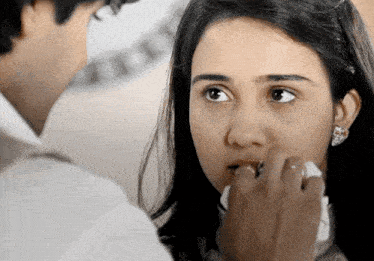 a man wipes a woman 's mouth with a napkin