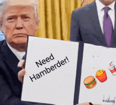 a man in a suit and tie holds up a sign that says need hamberder