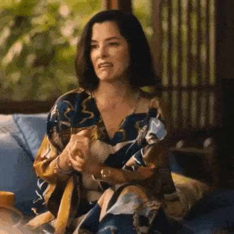 a woman in a floral dress is sitting on a couch .
