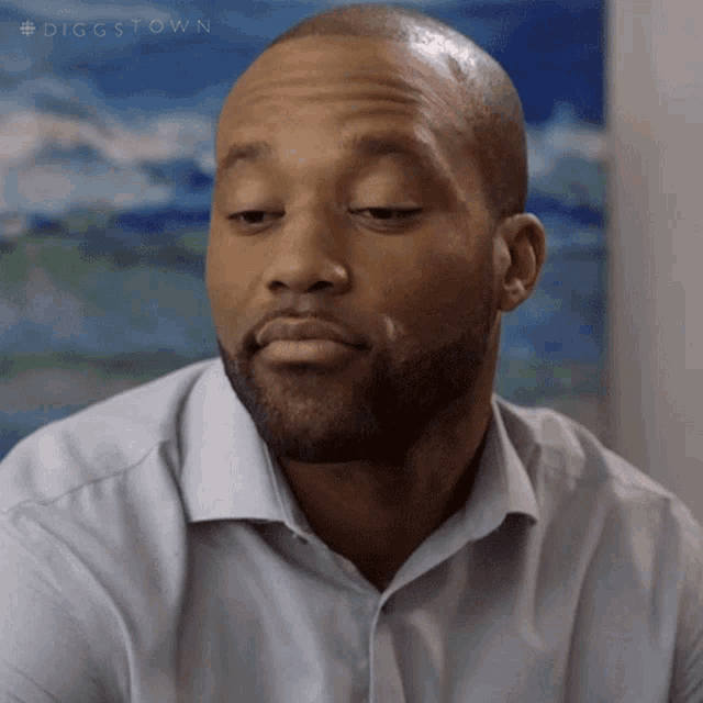 a man with a beard wearing a light blue shirt with the hashtag #diggstown
