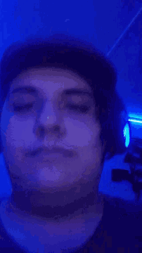 a close up of a person 's face in a dark room with blue lights .