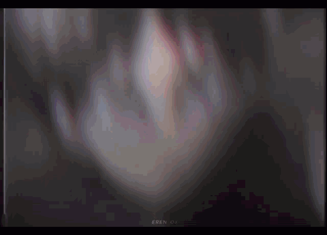 a close up of eren from attack on titan looking at the camera with a blurry background .