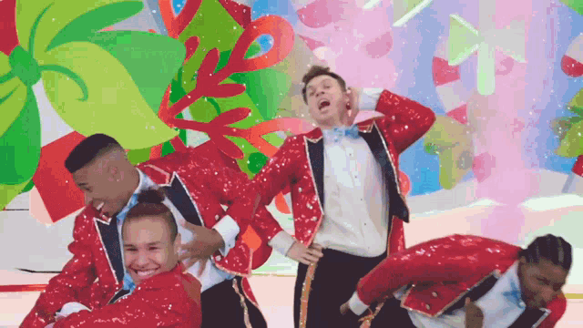 a group of people in red sequined suits are dancing