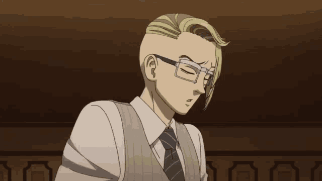 a man with glasses and a shaved head looks down