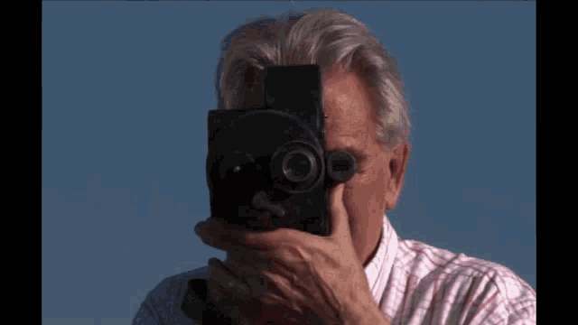 a man in a plaid shirt is holding a camera