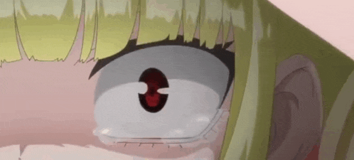 a close up of a girl 's face with a red eye and tears coming out of her eyes .