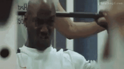 a man is lifting a barbell in front of a mirror .