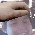 a close up of a person 's face with a hand reaching out to touch it .