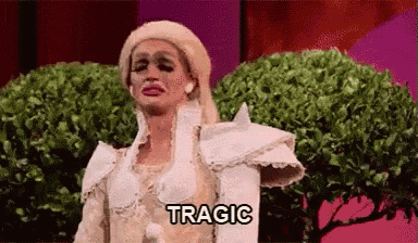a woman in a white dress and wig is crying and the word tragic is written on the screen .