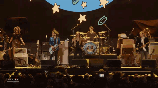 a band playing on stage with a sign that says stage live