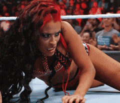 a woman in a bikini is crawling on the floor in a wrestling ring
