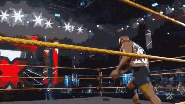 a wrestler in a ring with a blue light coming out of it