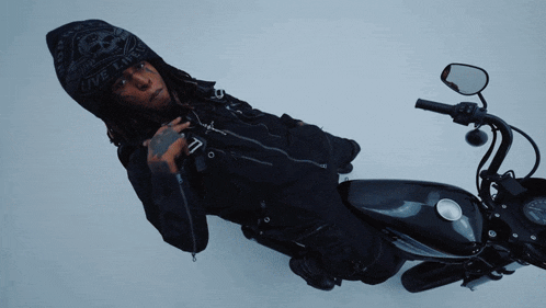 a man laying on a motorcycle wearing a hoodie that says live