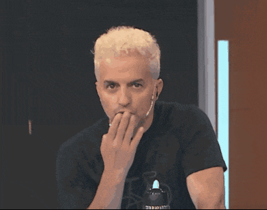a man with blonde hair and a black shirt has a microphone on his ear