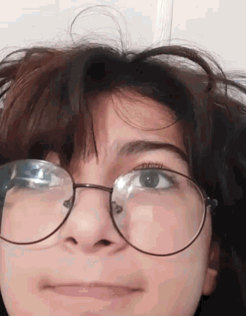 a close up of a person wearing glasses making a face