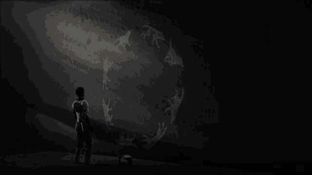 a man is standing in front of a wall with drawings of animals on it