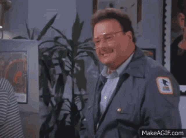 a man in a mailman 's uniform has a us postal service patch on his chest