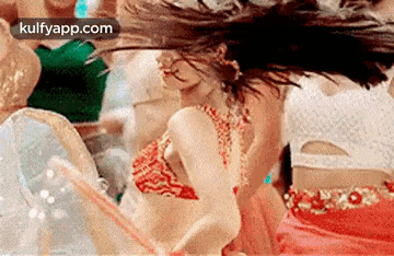 a woman in a red dress is dancing with a straw in her hand .