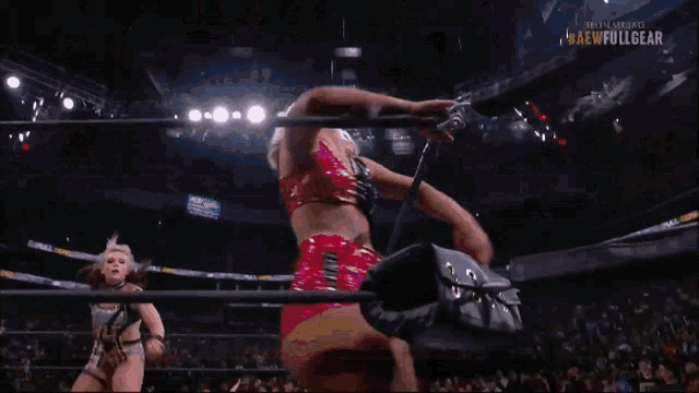 a woman in a wrestling ring with the word full gear on the bottom right