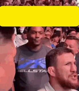 a man is standing in front of a crowd of people .
