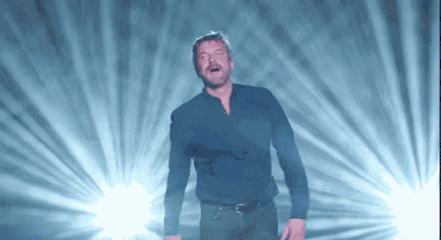 a man is standing in front of a blue light