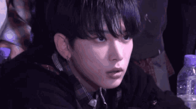 a close up of a person with a bottle of water in front of them