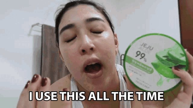 a woman is holding a jar of jeju aloe 99